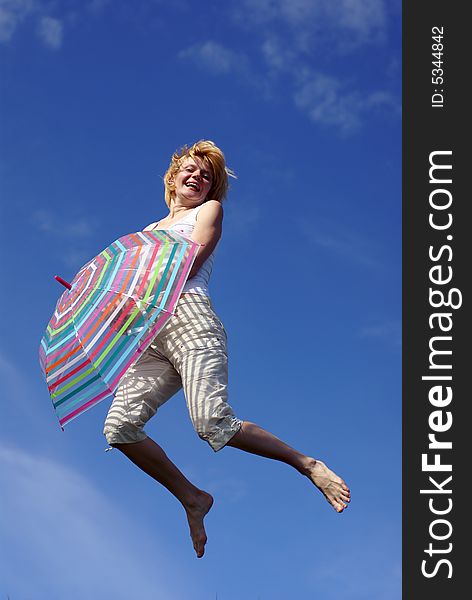 Young charming girl with umbrella against blue sky