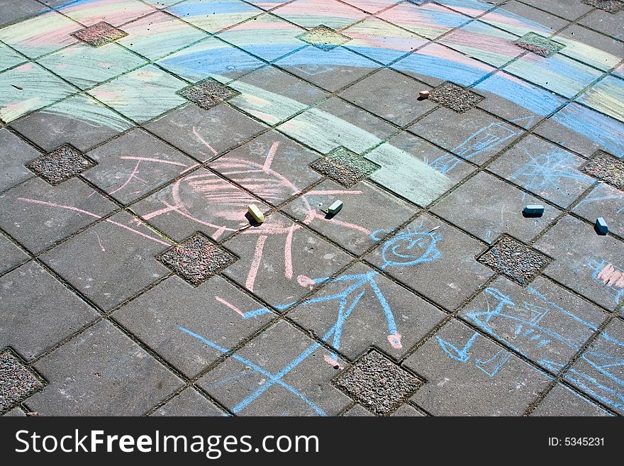 Children chalk drawings at street pavement