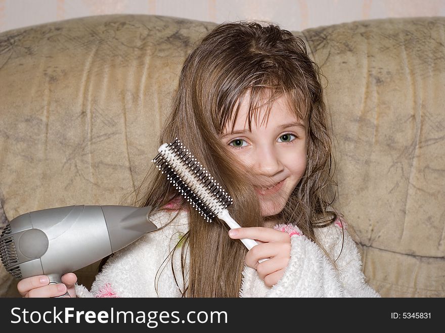 The little girl dries hair after bathing. The little girl dries hair after bathing