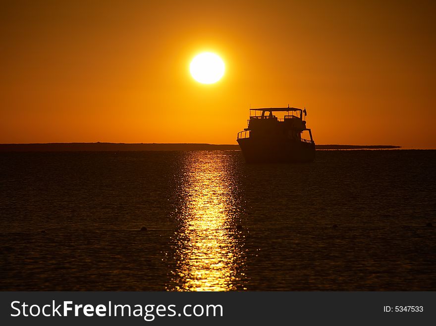 Boat silhouette and golden sunrise over the ocean. Boat silhouette and golden sunrise over the ocean