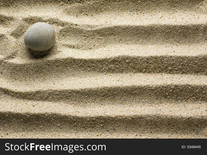 Sand pattern with pebble on it