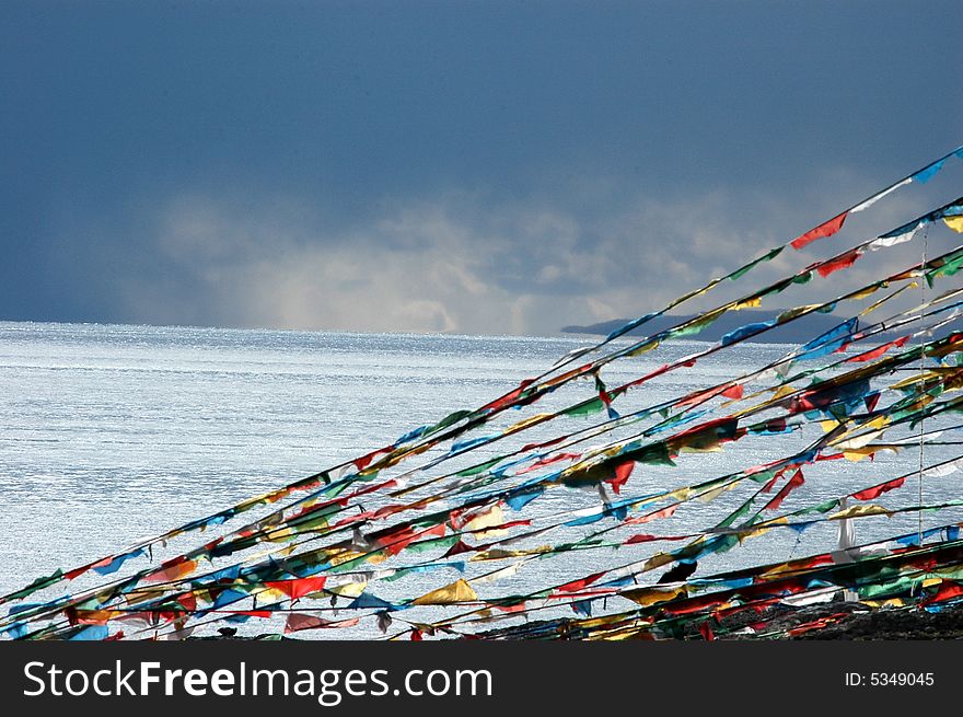 The strings of colorful buddhist flags by the Lake Namutso, the signs of blessing in Tibetan Lama Buhddhism,a saint lake in the Tibet,China. The strings of colorful buddhist flags by the Lake Namutso, the signs of blessing in Tibetan Lama Buhddhism,a saint lake in the Tibet,China.