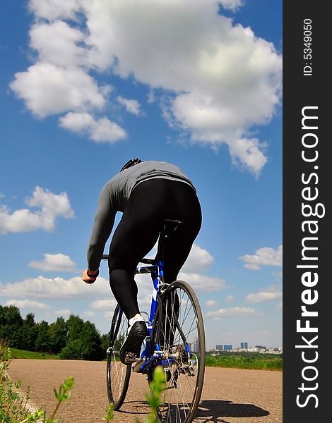 Bicyclist on a background of the blue sky