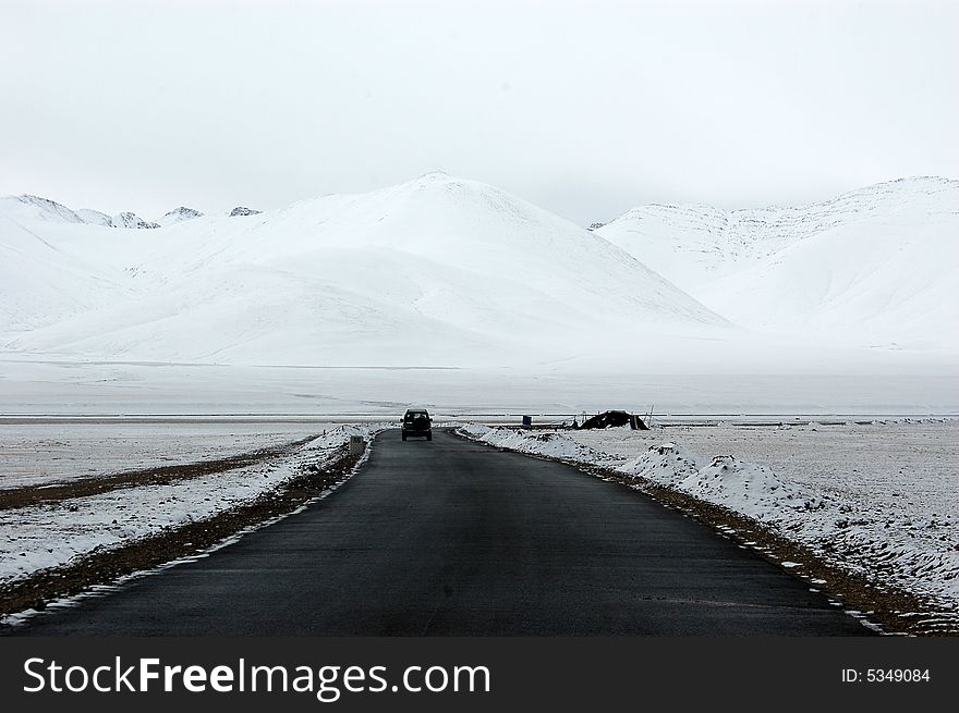 An asphalt road in the snow covered land in Tibet,China. An asphalt road in the snow covered land in Tibet,China.