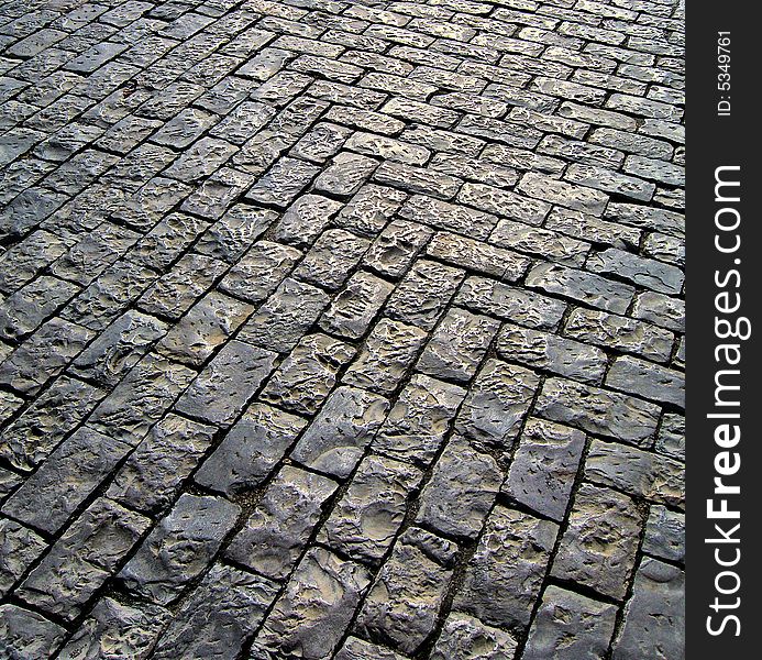 Typical portuguese pavement with the glow of the sun shinning on the surface.