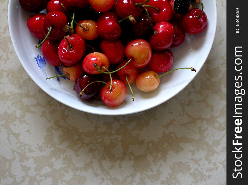 Cherry peach and blackberry are in the plate of white.