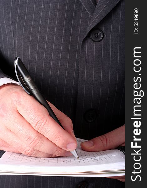 Businessman hand signing paperwork/document or making notes close-up isolated. Businessman hand signing paperwork/document or making notes close-up isolated