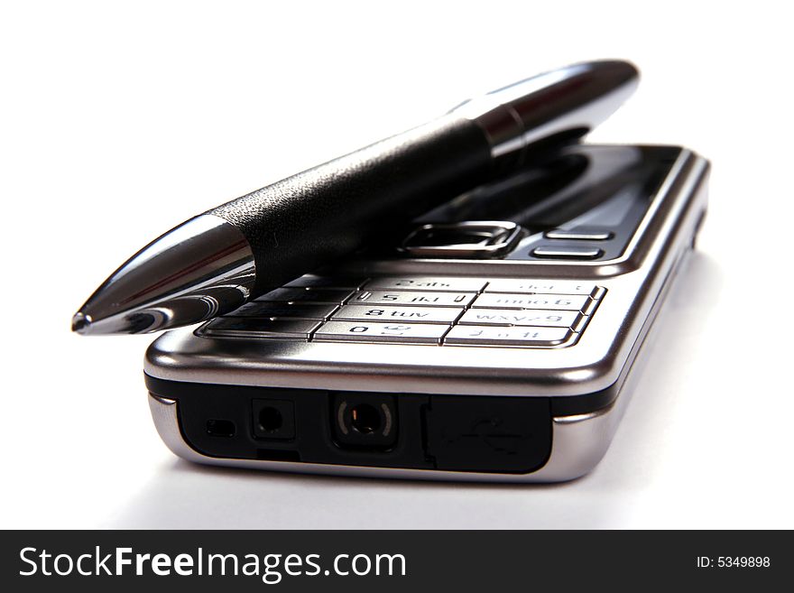 Silver mobile phone and pen close-up isolated