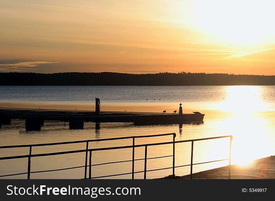 Beautiful sunrise with bridge in silhouette in front of water