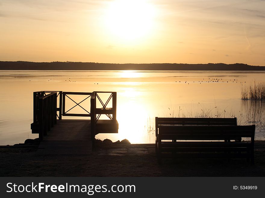 Beautiful sunrise with bridge in silhouette in front of water