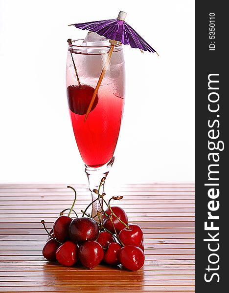 A red cocktail in a glass with cherry and ice. A red cocktail in a glass with cherry and ice