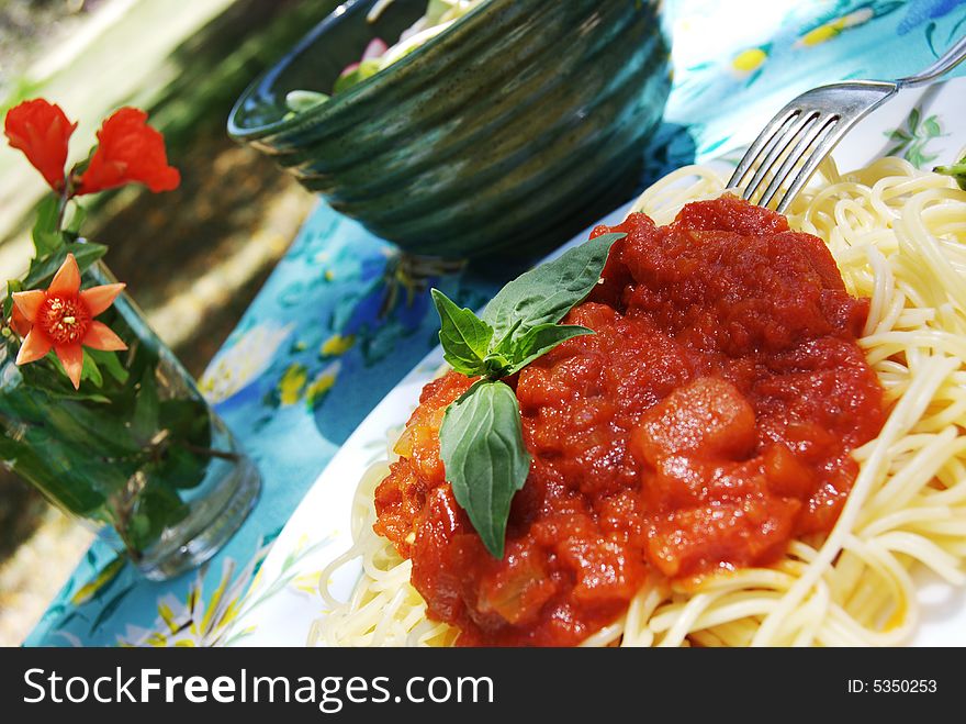 Spaghetti with tomato sauce on the background of table
