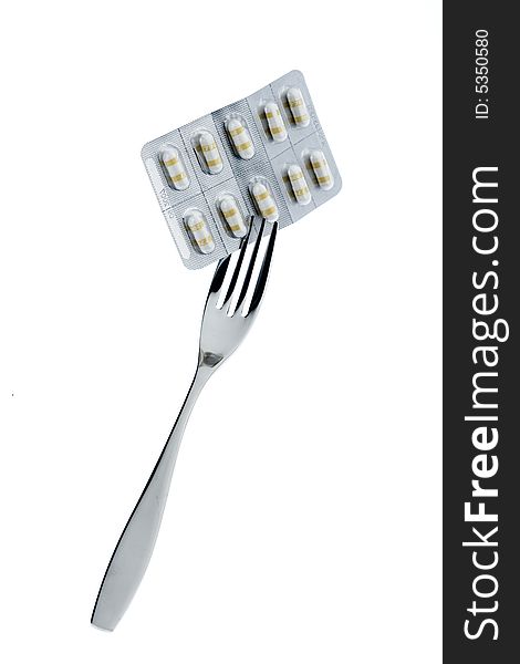 Fork with pills on a white background. Fork with pills on a white background