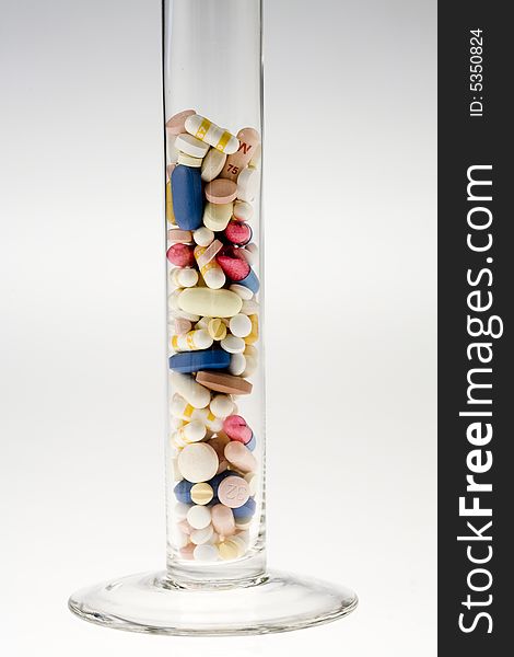 A jar filled with pills on white