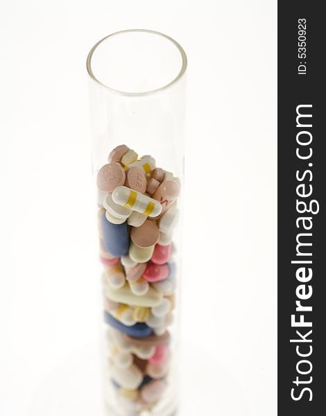 A jar filled with pills on white