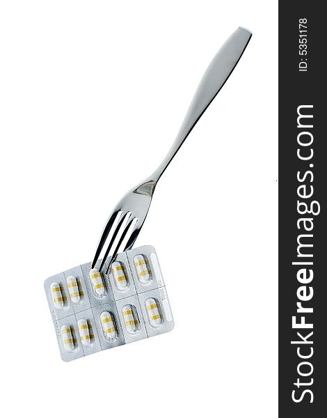 Fork with pills on a white background. Fork with pills on a white background