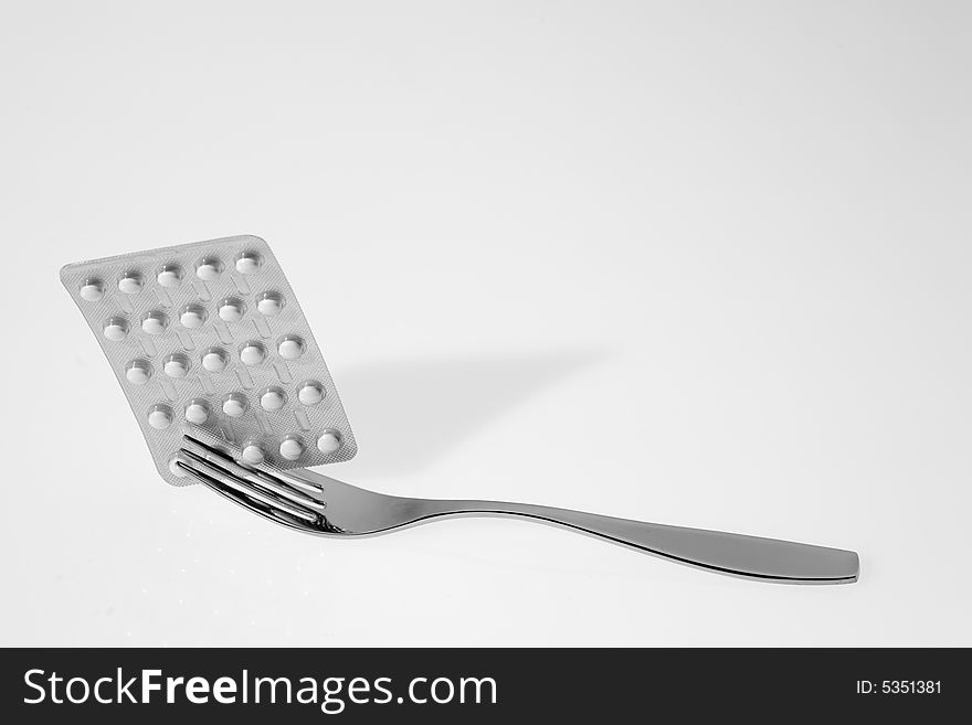 Fork with pills on a white background. Fork with pills on a white background
