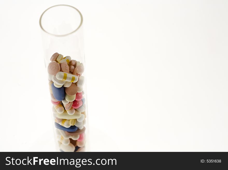 A jar filled with pills on white