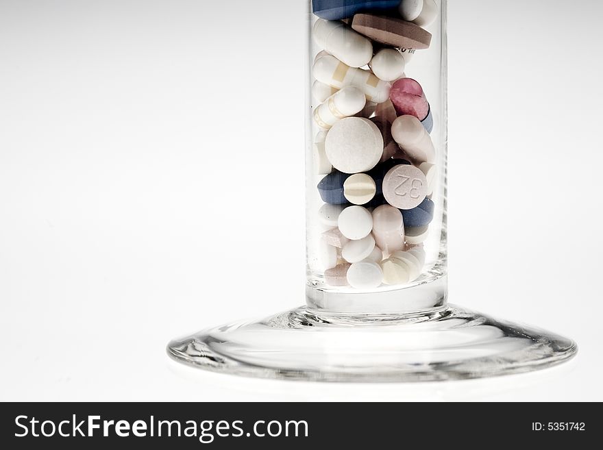 A jar filled with pills on white