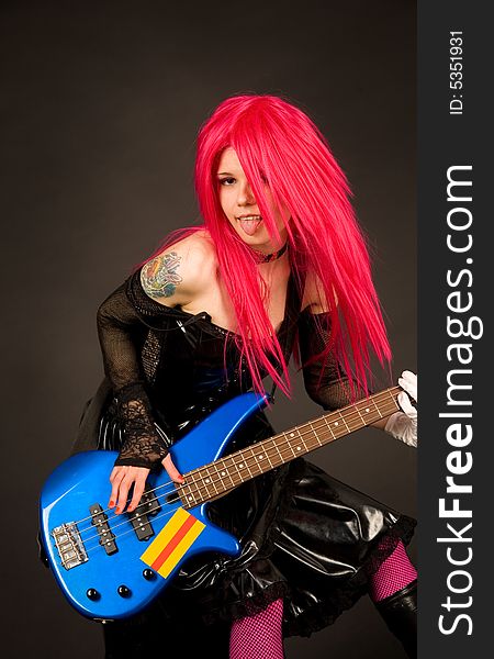 Girl showing tongue playing bass guitar