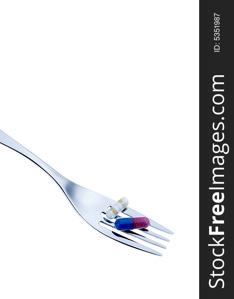 Pills with fork with a white background. Pills with fork with a white background