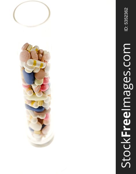 A jar filled with pills on white