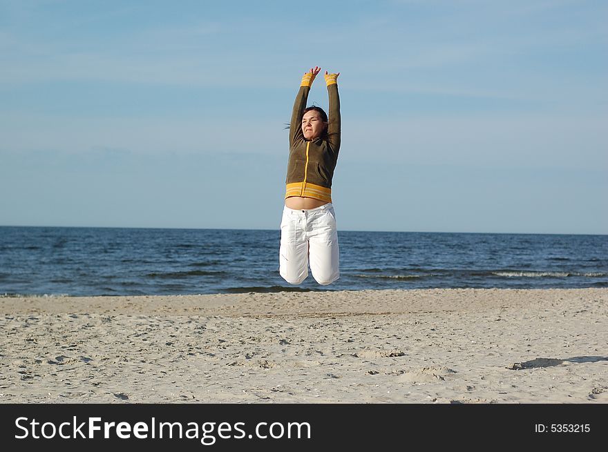 Attractive woman jumping on the beach