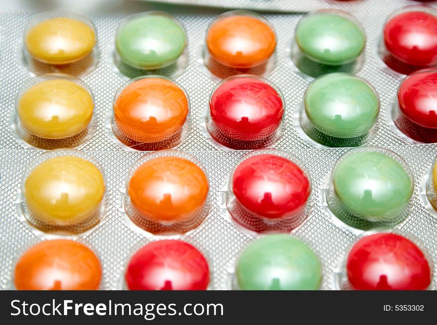 Colorful green yellow and orange pills background. Colorful green yellow and orange pills background