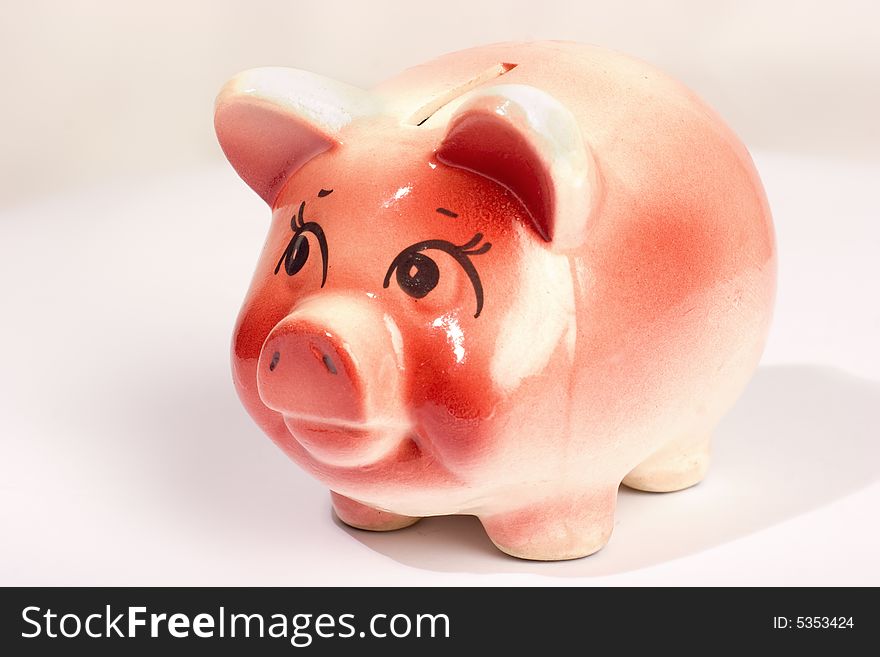 Pink ceramic piggy-bank isolated over white