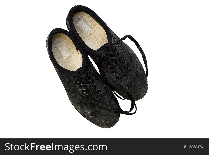 Worn black canvas fabric sneakers with black laces isolated against white background. Worn black canvas fabric sneakers with black laces isolated against white background