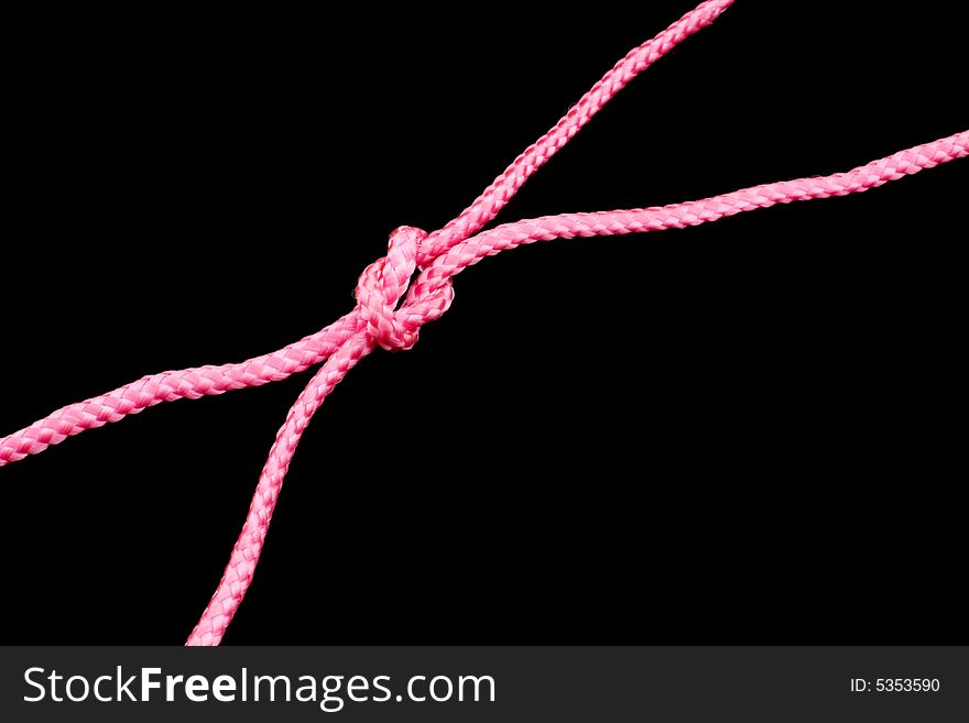 Pink ropes tied together, black background. Pink ropes tied together, black background