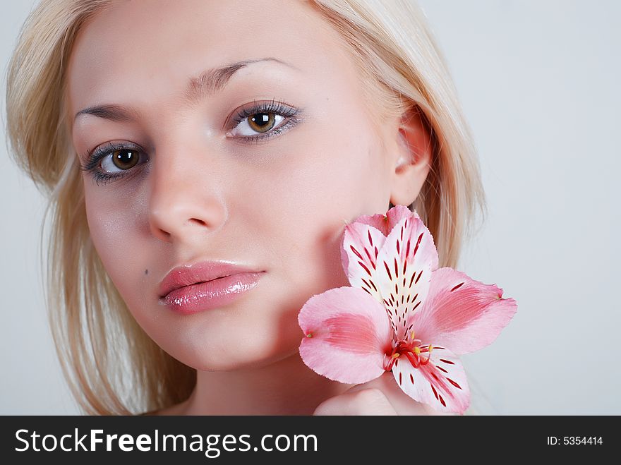 The beautiful girl with a flower of an orchid in the left hand. The beautiful girl with a flower of an orchid in the left hand