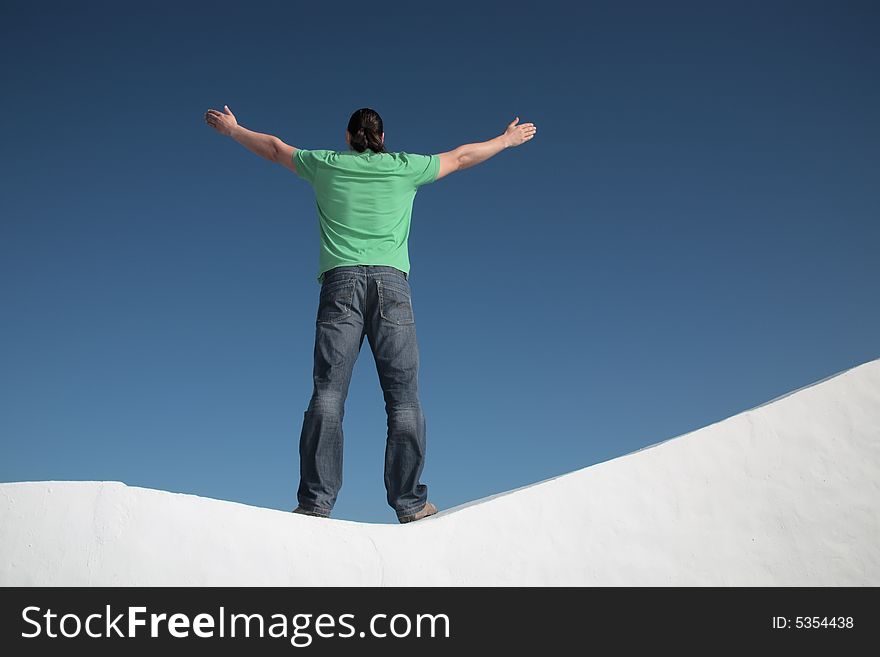 Young man with arms wide open against sky background
