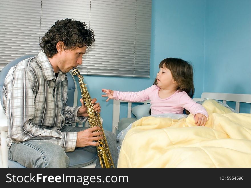 A Father Playing Saxophone For Daughter In Bed