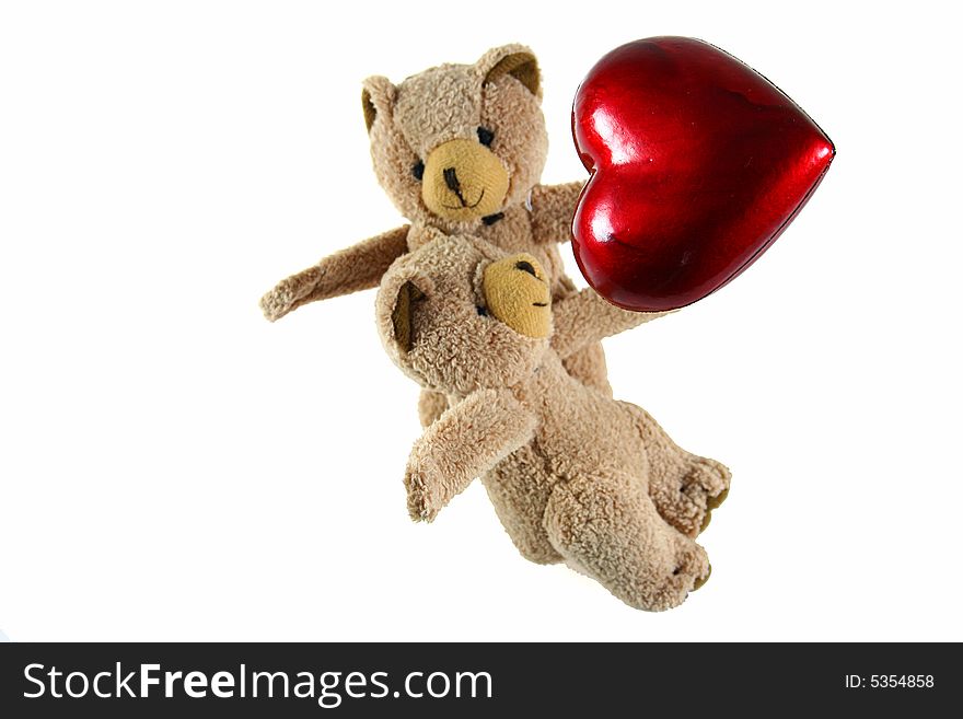 Two teddybears with red heart as symbol for love on white background as one of my isolated objects. Two teddybears with red heart as symbol for love on white background as one of my isolated objects
