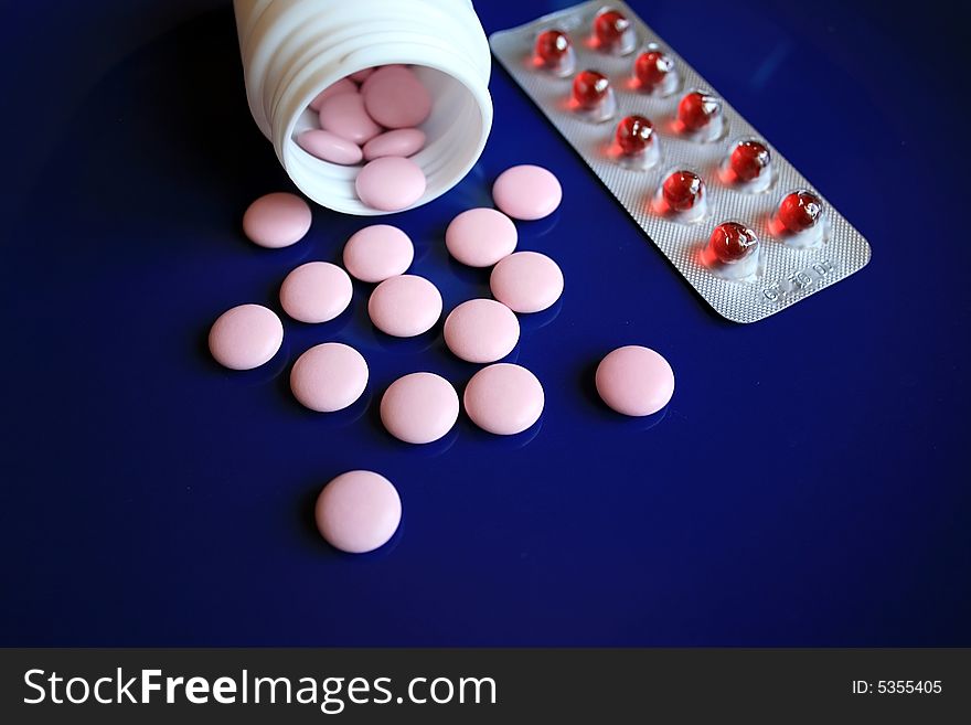 Tablets and pills on a dark blue background. Tablets and pills on a dark blue background.