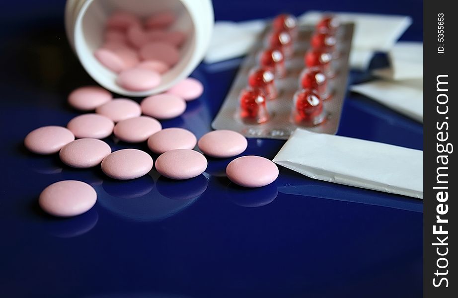 Tablets and pills on a dark blue background. Tablets and pills on a dark blue background.