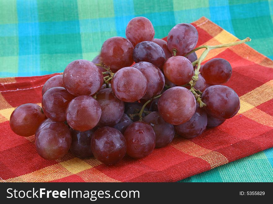 The bunch of ripe red grapes on the white background. The bunch of ripe red grapes on the white background