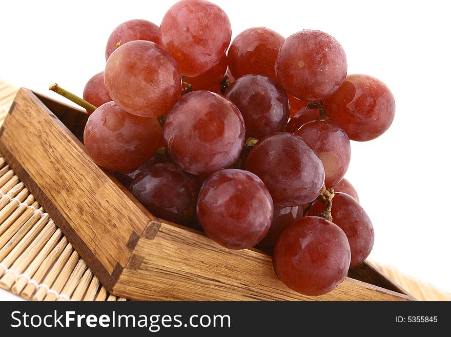 The bunch of ripe red grapes on the white background. The bunch of ripe red grapes on the white background