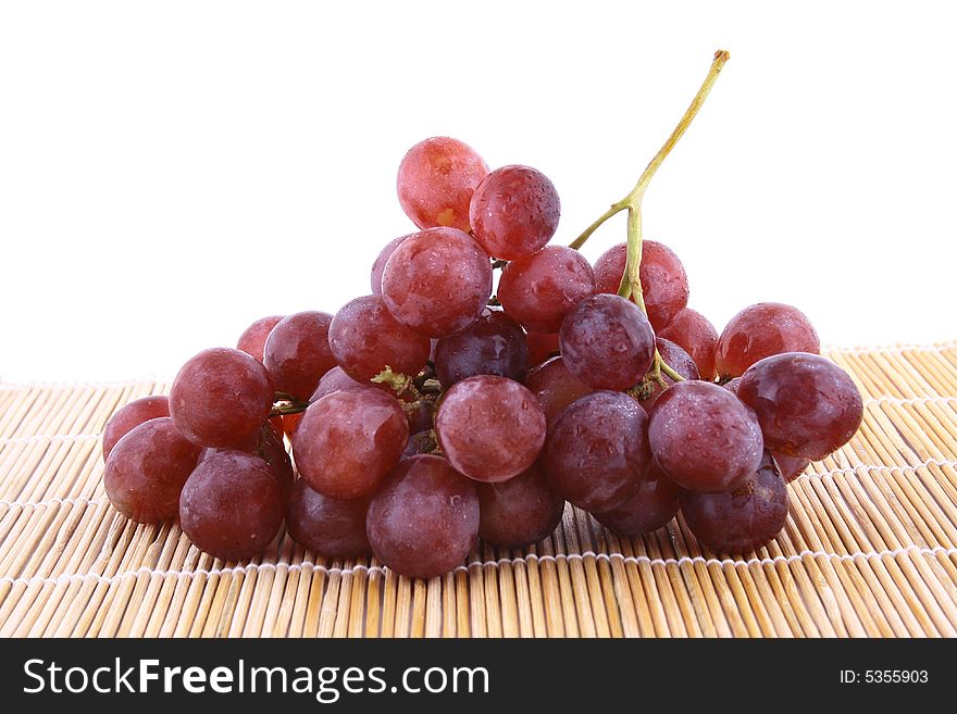 The bunch of ripe red grapes on the white background. The bunch of ripe red grapes on the white background