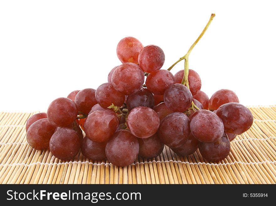 The bunch of ripe red grapes on the white background. The bunch of ripe red grapes on the white background