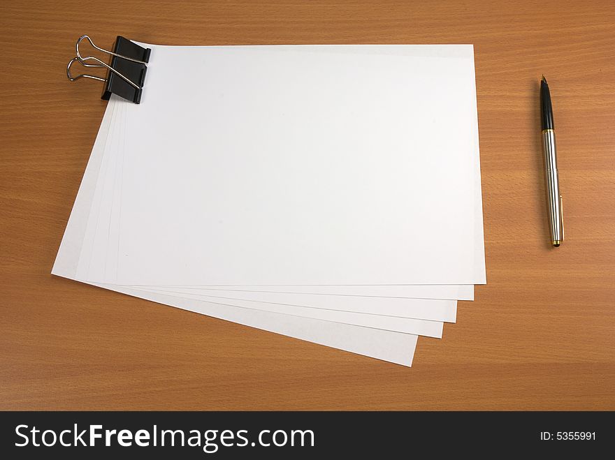 Blank papers and pen on wooden table surface. Blank papers and pen on wooden table surface.