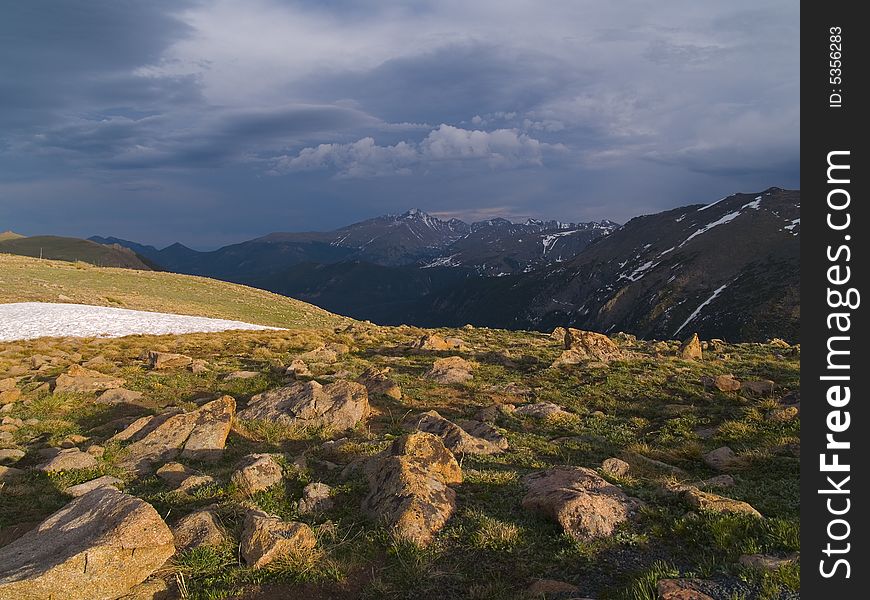 Trail Ridge in Rocky Mountain National Park with evening shadows and a distant storm over Longs Peak. Trail Ridge in Rocky Mountain National Park with evening shadows and a distant storm over Longs Peak.