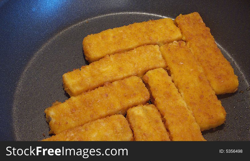 Rows of fish sticks in a pan