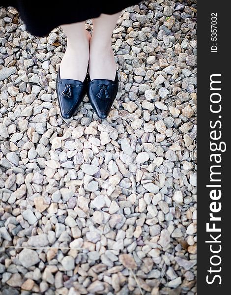 Close view of businesswoman formal shoes on rocks. Close view of businesswoman formal shoes on rocks