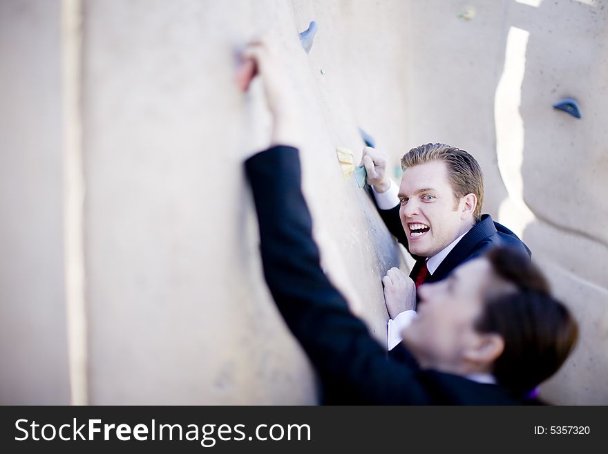 Businessman and businesswoman competing by climbing on wall. Businessman and businesswoman competing by climbing on wall