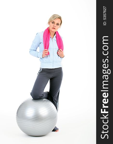 Blond woman in gym outfit exercising with a pilates ball isolated on white