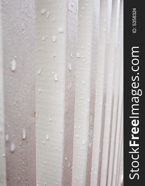 White painted wooden posts shown in profile with waterdrops. White painted wooden posts shown in profile with waterdrops