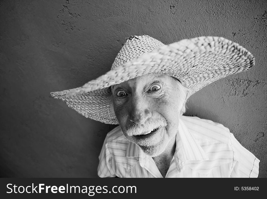 Senior Citizen Man Wearing a Straw Cowboy Hat Looks Off. Senior Citizen Man Wearing a Straw Cowboy Hat Looks Off