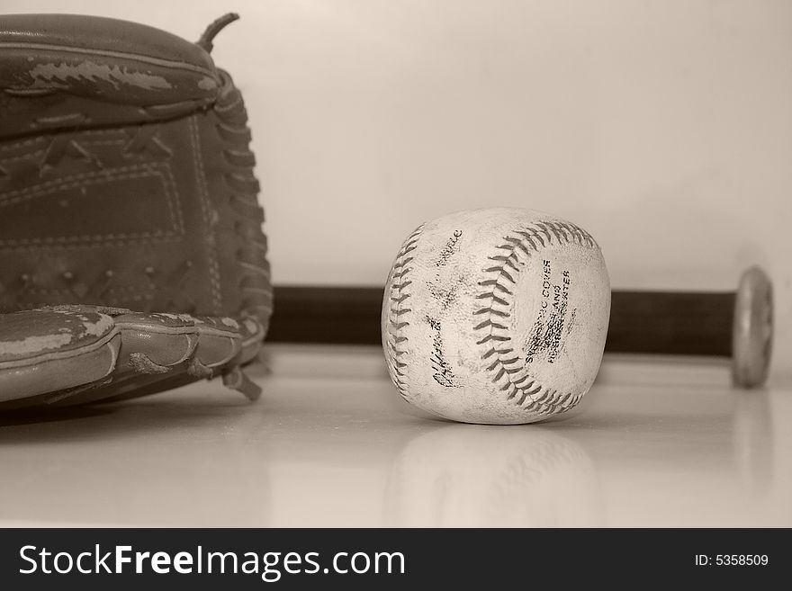 Close up of a vintage baseball and a baseball mitt and bat